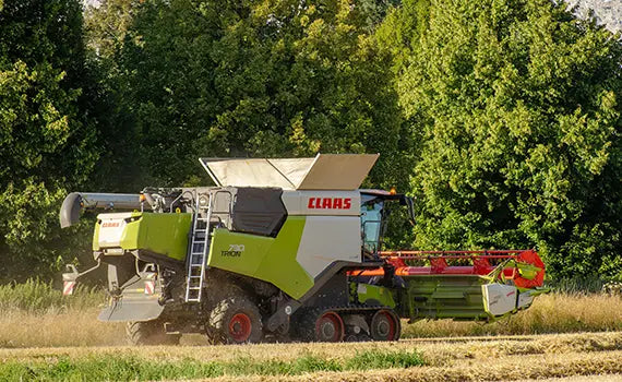 A Farmer using a combine harverter to harvest wheat